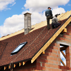 Roofers lay and install asphalt shingles. Roof repair with two roofers. Roofing construction with roof tiles, asphalt shingles.